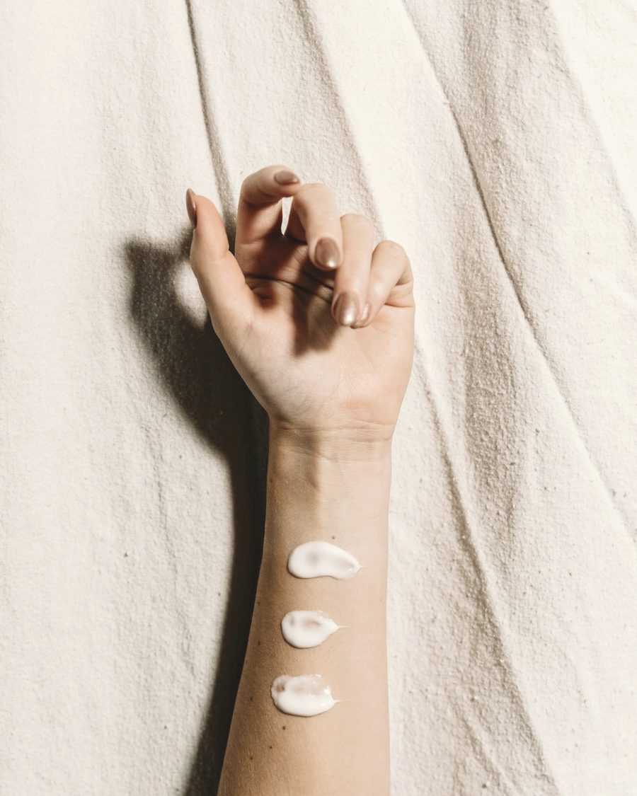 Skincare on skin against soft linen